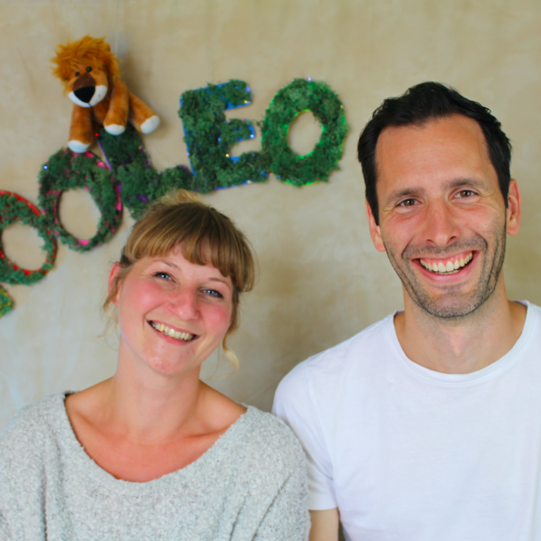YOOLEO Gründer-Team 2022 Gianna und Simon sind das Gründer-Team von YOOLEO. Sie sitzen nebeneinander und lächeln