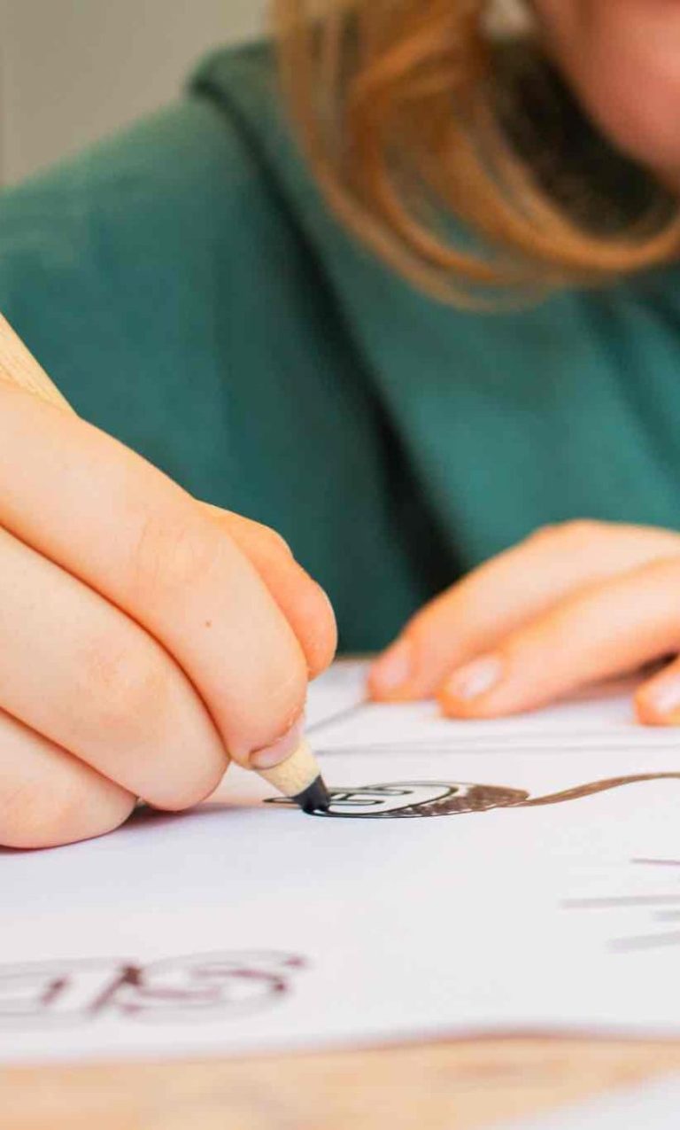 Kind malt nach Mediennutzung Eine Person zeichnet mit einem Stift auf weißem Papier.